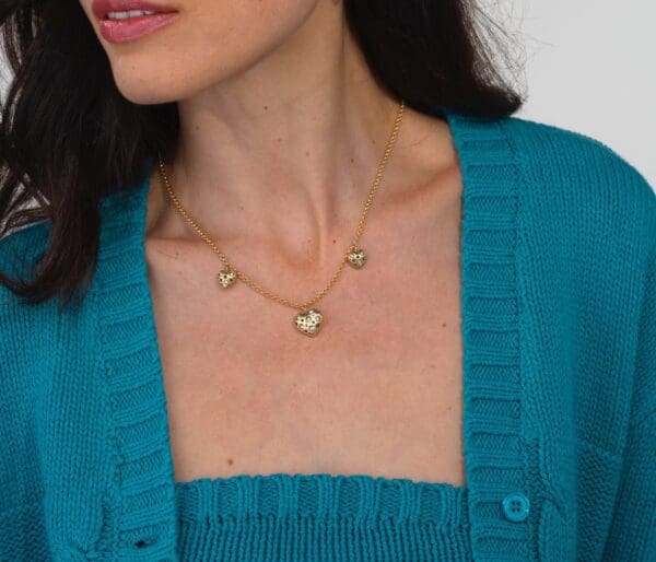 A woman wearing a blue sweater and necklace.