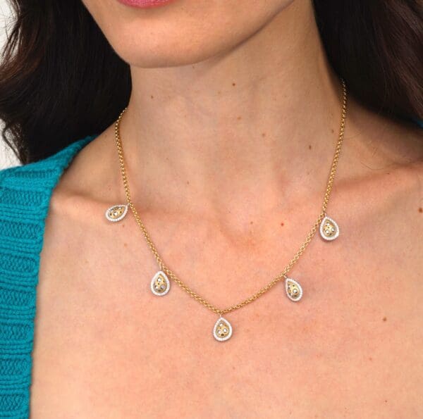 A woman wearing a necklace with five small circles.