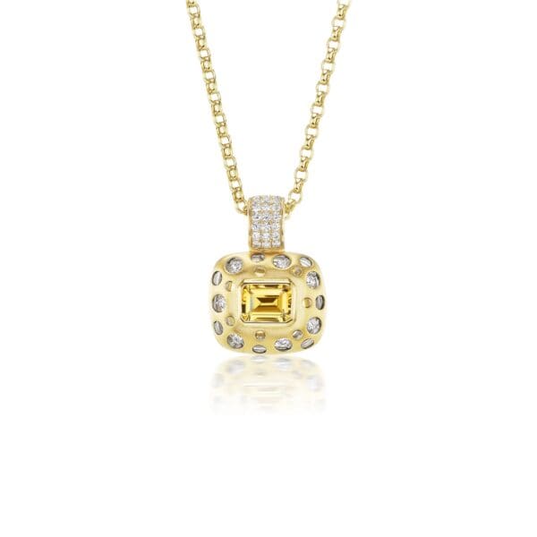 A yellow diamond and white gold pendant necklace.