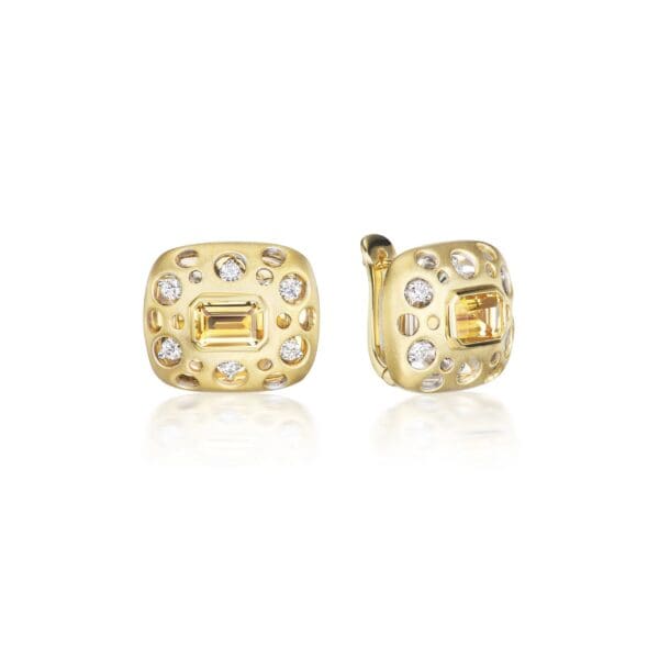 A pair of gold earrings with diamonds on top.