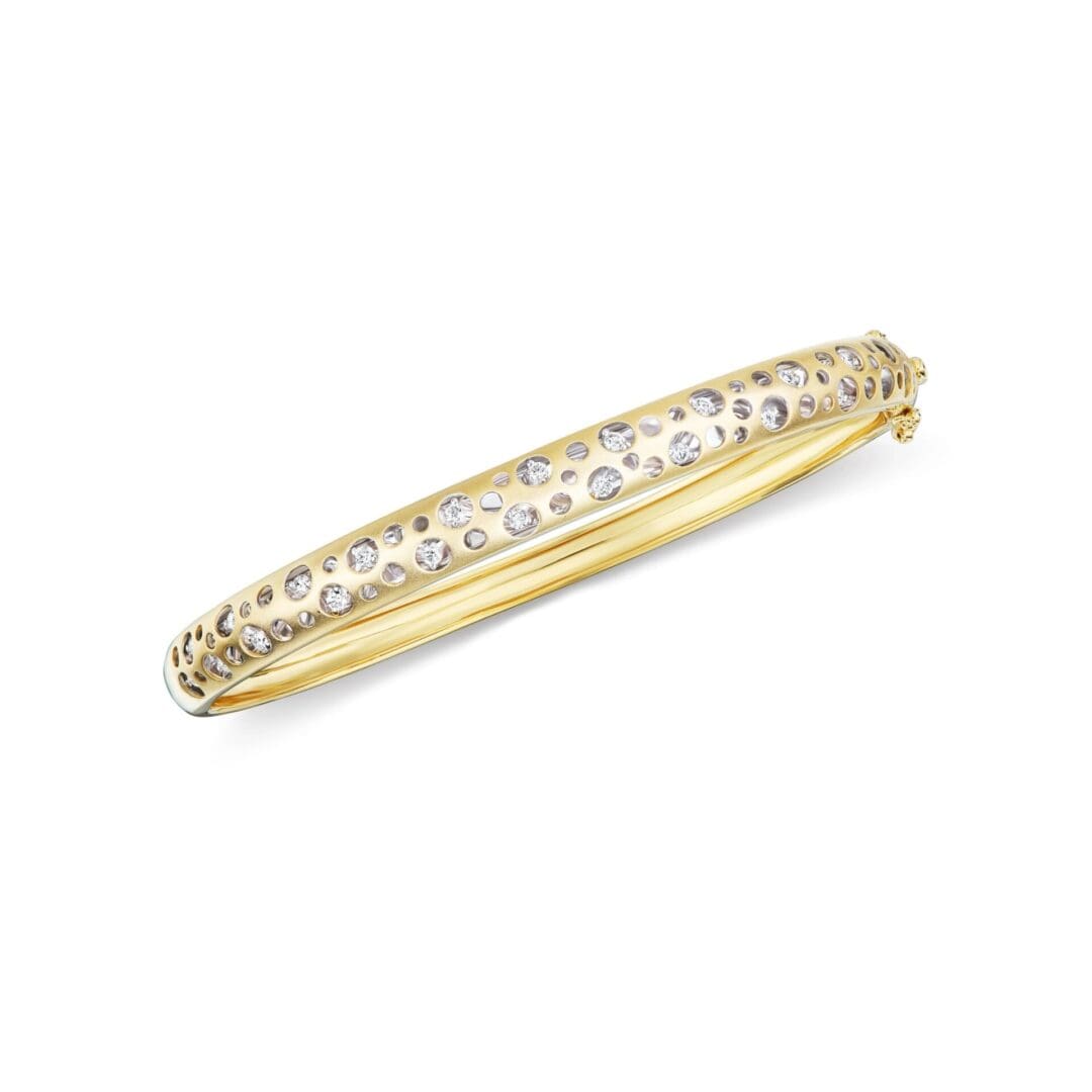 A gold and diamond bangle bracelet.