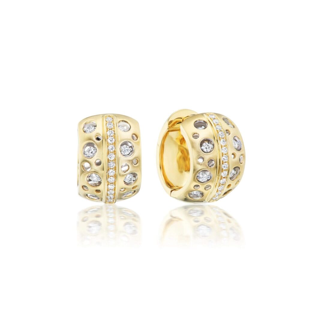 A pair of gold earrings with diamonds on top.