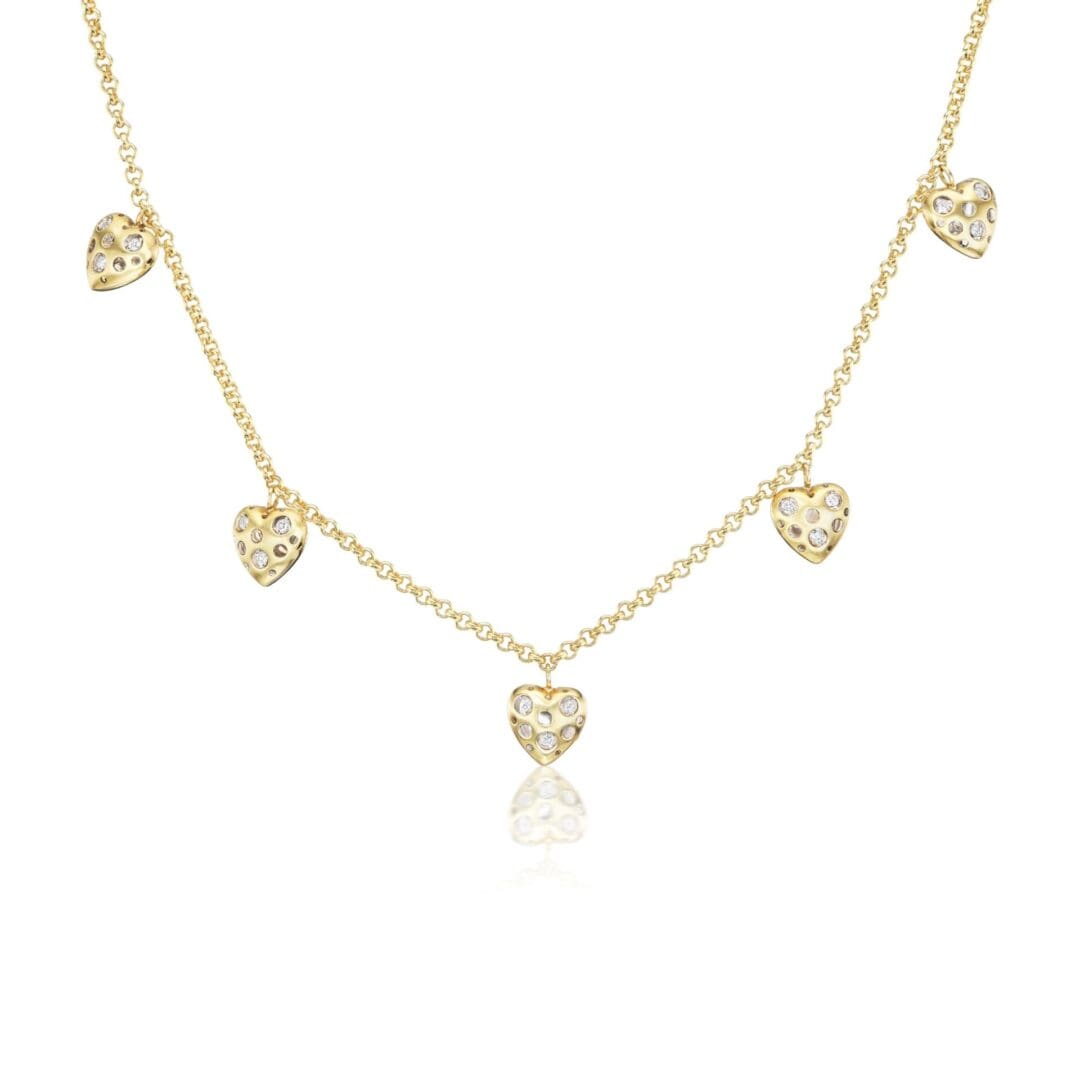 A gold necklace with five hearts hanging from it.