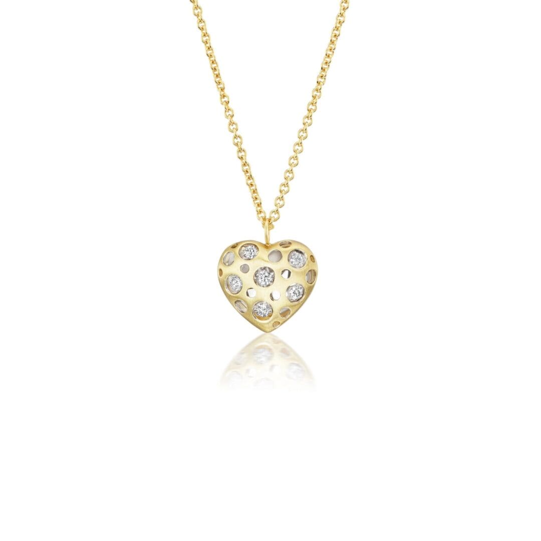A gold necklace with a heart shaped pendant.