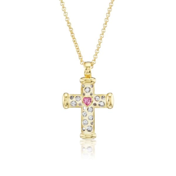 A gold cross with pink and white stones.