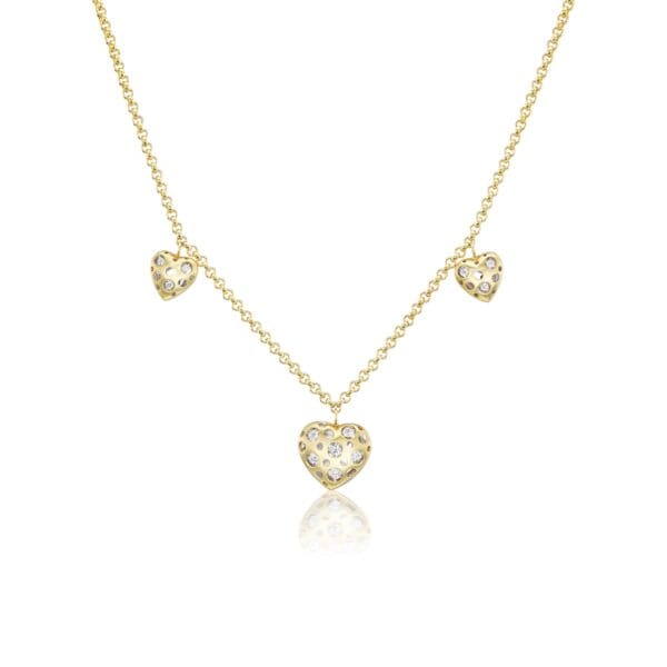 A gold necklace with three hearts on it