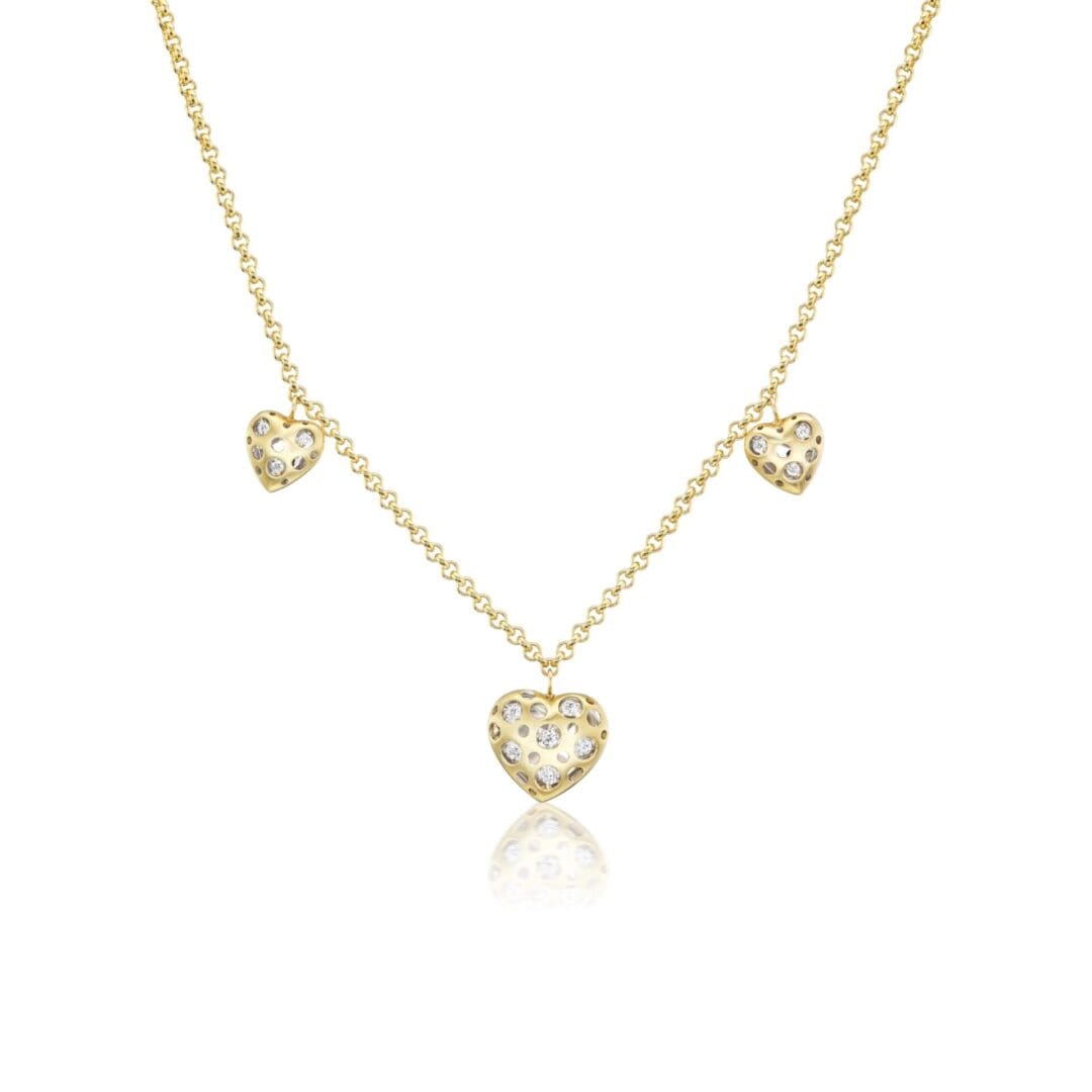 A gold necklace with three hearts on it