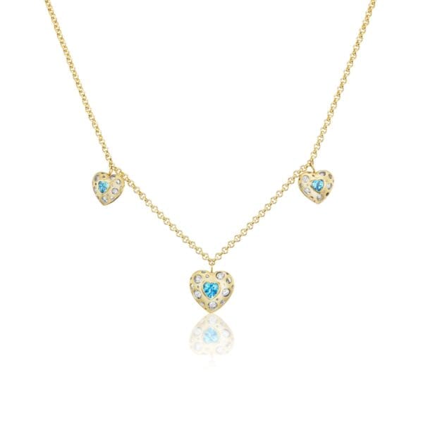 A gold necklace with three blue hearts on it.