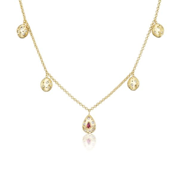 A gold necklace with five dangling charms.