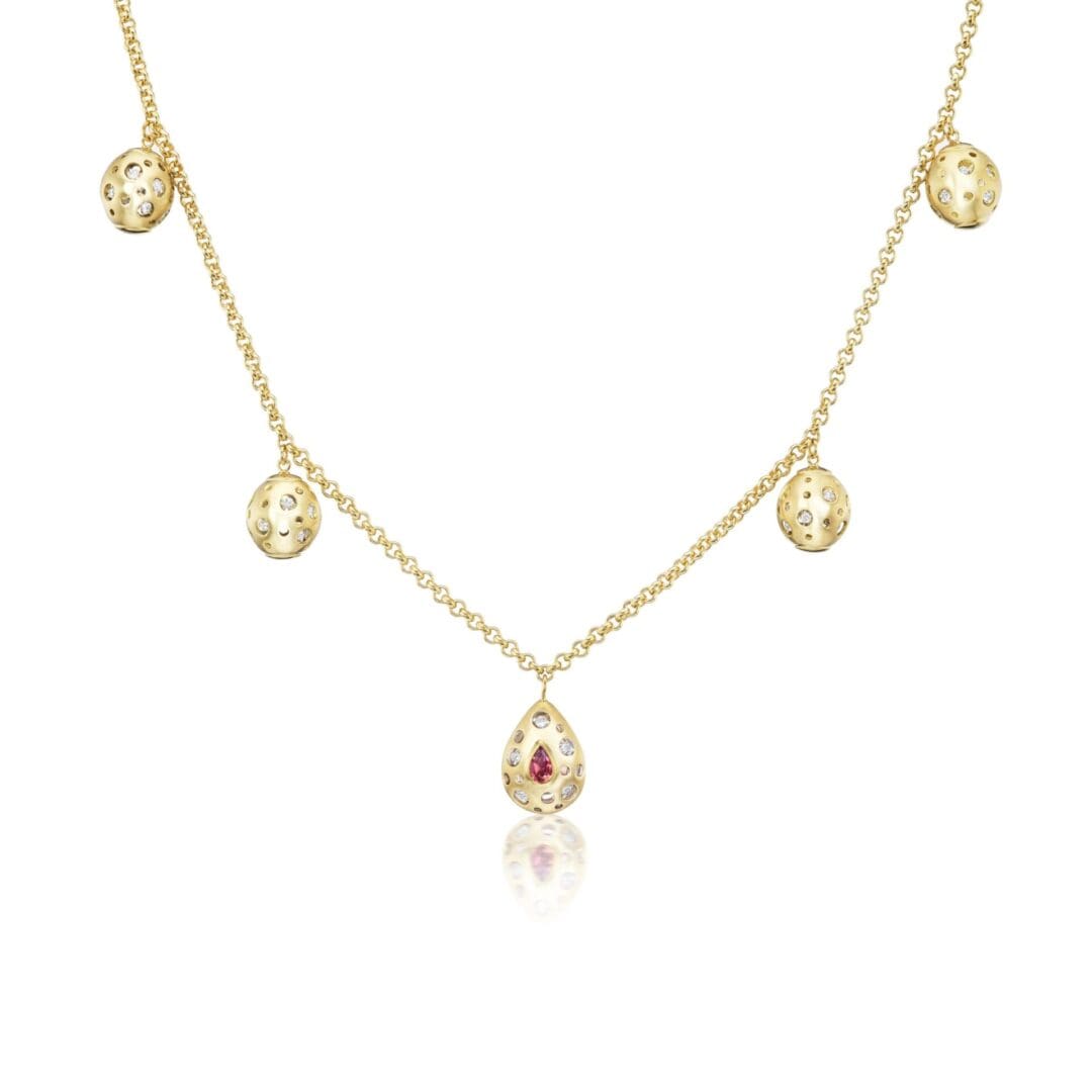 A gold necklace with five dangling charms.