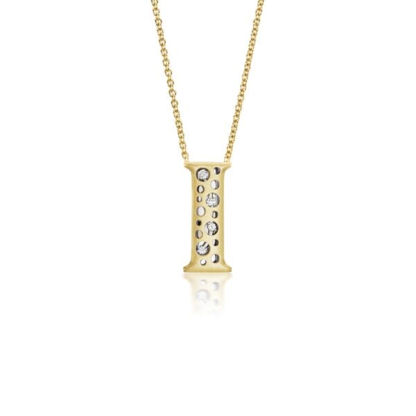 A gold necklace with a letter i on it