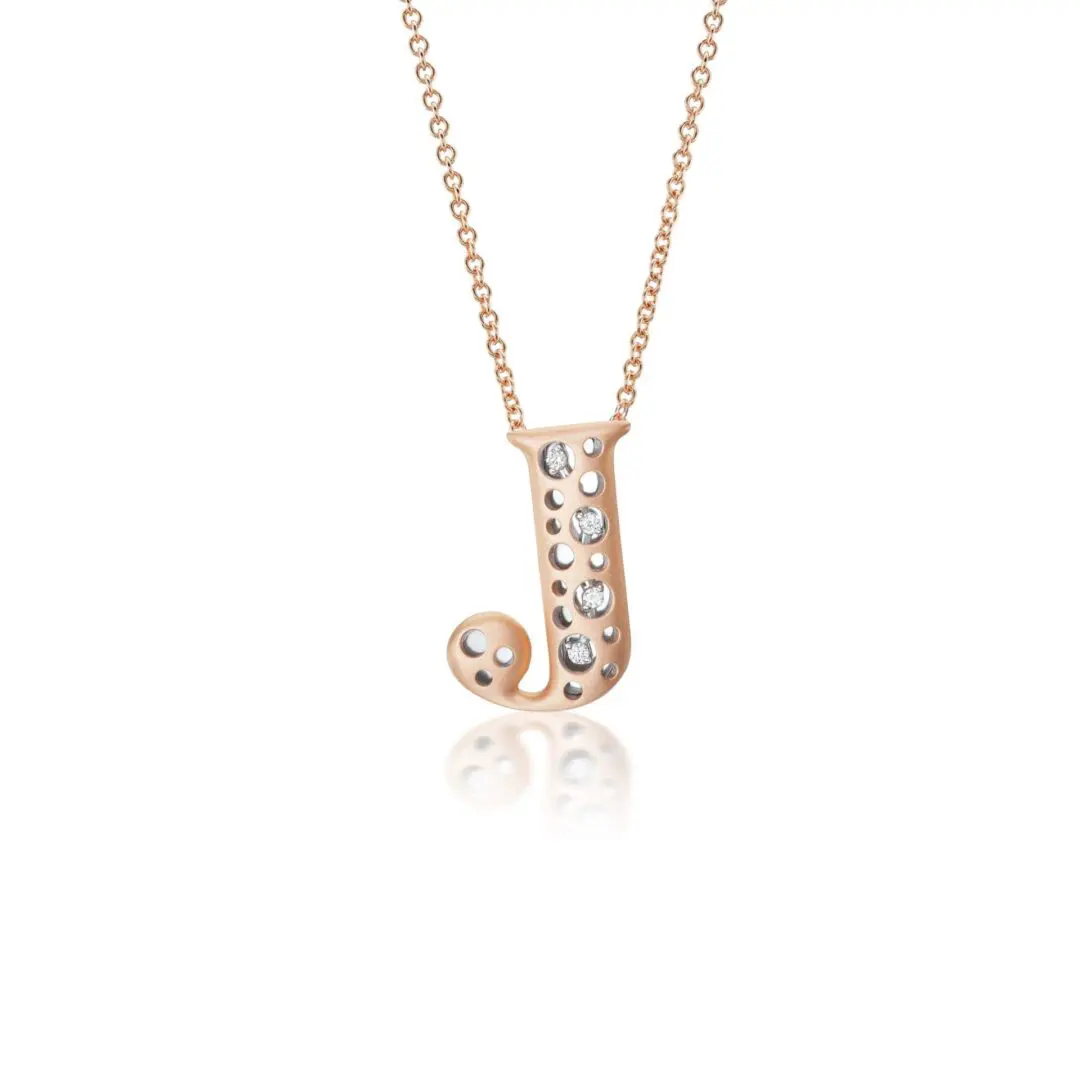 A rose gold necklace with a letter j on it.