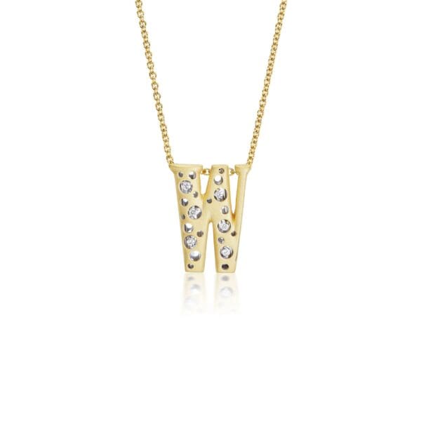 A gold necklace with two letters and diamonds.