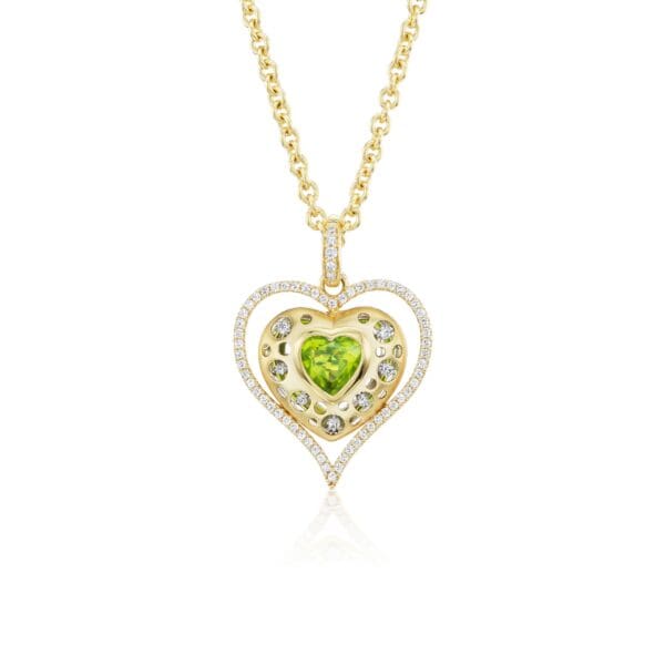 A gold necklace with a heart shaped stone.