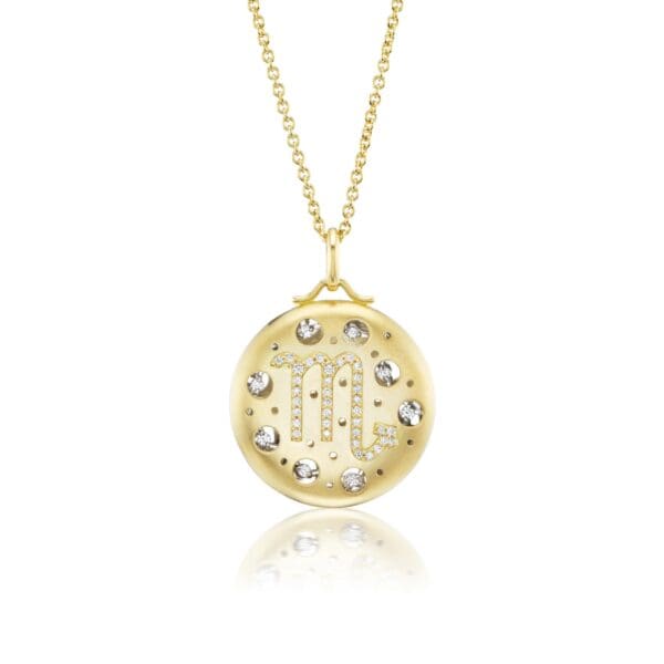 A gold necklace with a diamond and letter pendant.