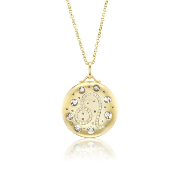 A gold necklace with a round pendant and diamond accents.