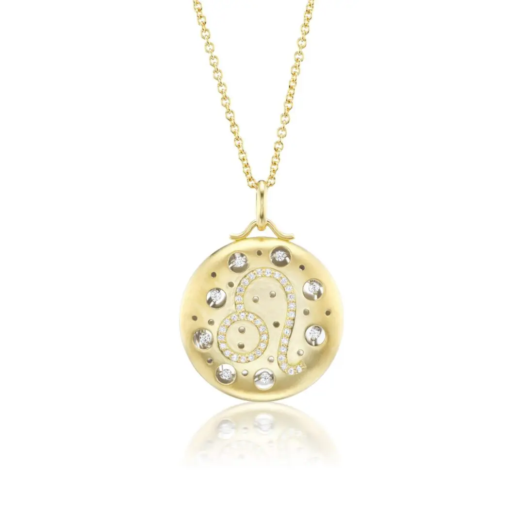 A gold necklace with a round pendant and diamond accents.