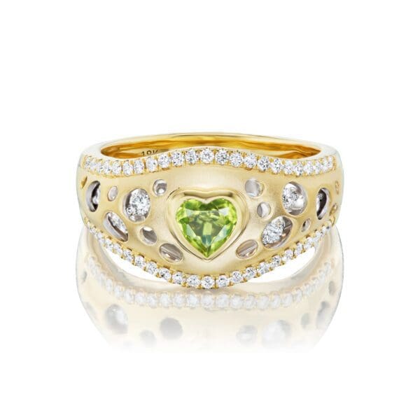 A gold ring with a heart shaped stone on it's side.