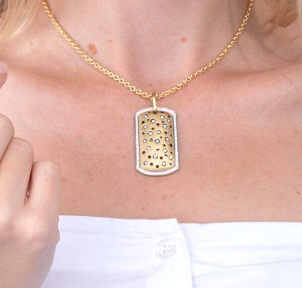 A woman wearing a gold necklace with a white shirt.