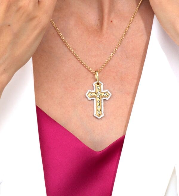 A woman wearing a pink dress and holding onto a cross