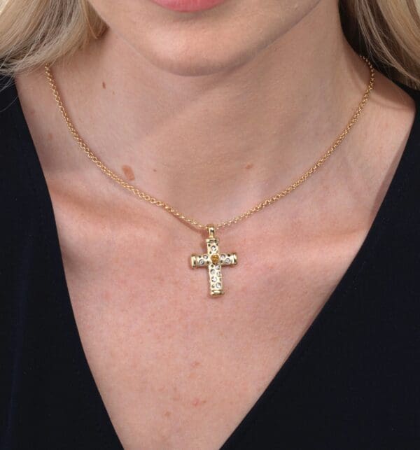 A woman wearing a necklace with a cross on it.