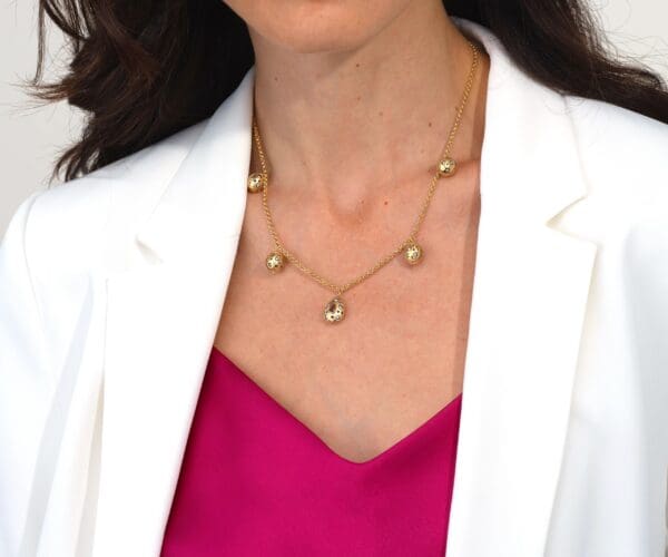 A woman wearing a white jacket and pink top.